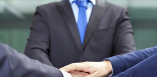 three people in suits shaking hands teamwork