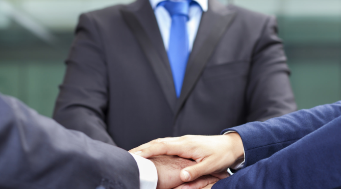 three people in suits shaking hands teamwork