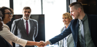 african american business woman shaking hands with man in meeting