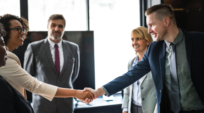 african american business woman shaking hands with man in meeting