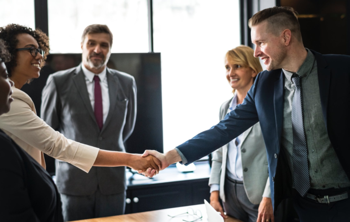 african american business woman shaking hands with man in meeting