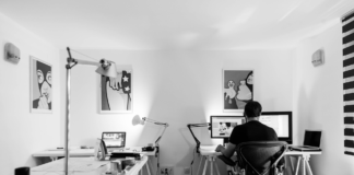 man sitting alone in office with computer black and white