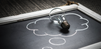 light bulb laying on chalk board with thought bubble