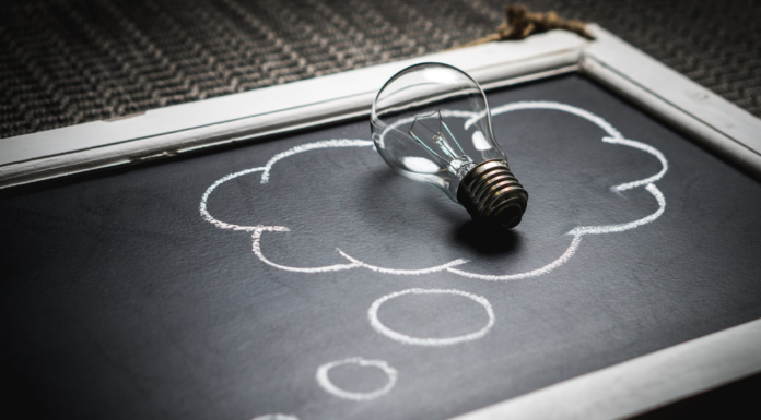 light bulb laying on chalk board with thought bubble