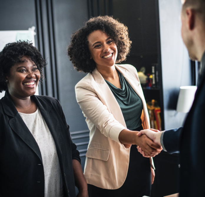 African american woman shaking hands with a man at work