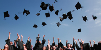 people at graduation throwing their caps in the air