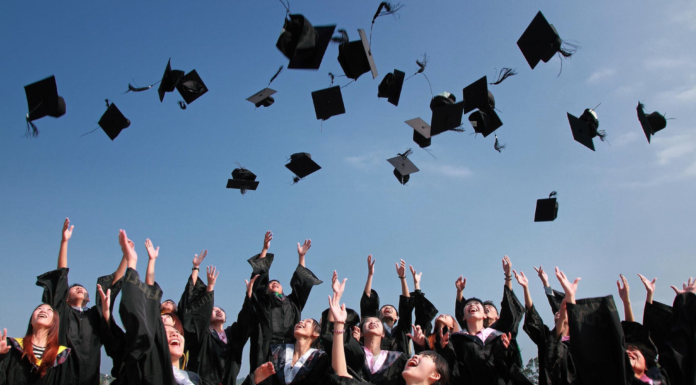 people at graduation throwing their caps in the air