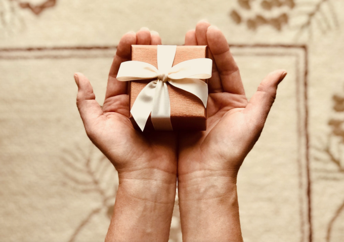 person holding tiny wrapped present