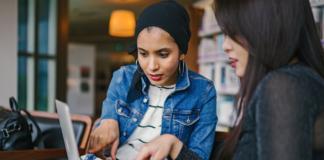 diverse women holding laptop talking