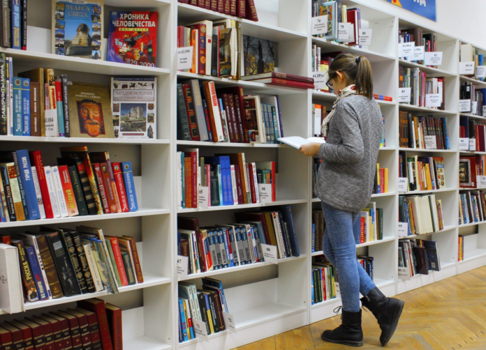 student looking a books in library