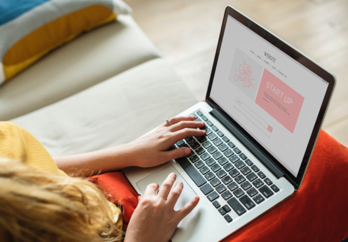 woman with laptop resting on knees doing work