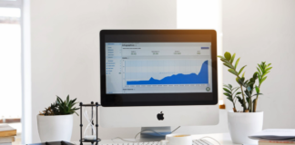 apple desk computer sitting on desk with analytics information on monitor