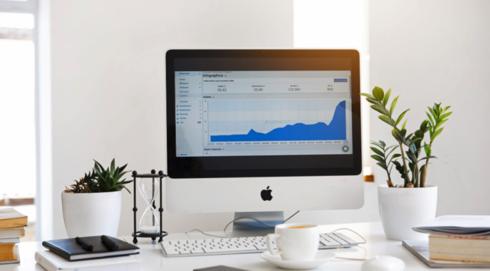 apple desk computer sitting on desk with analytics information on monitor