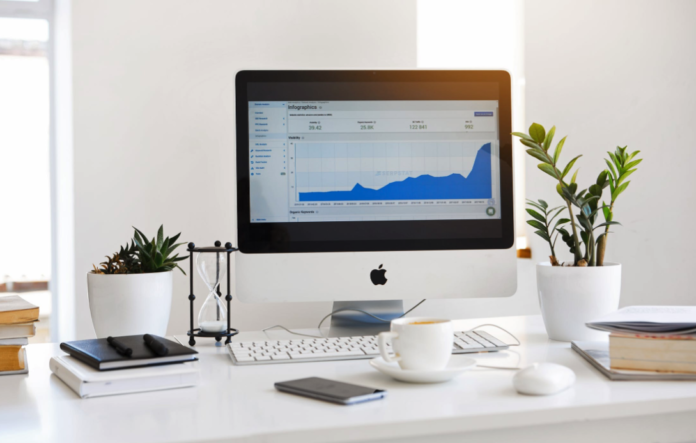 apple desk computer sitting on desk with analytics information on monitor